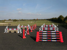 Load image into Gallery viewer, Photograph of the PolyJumps Advanced set in an arena. The set&#39;s contents are as follows: 1 set of Combi Blocks, 4 sets of Cross Wings and 3 sets of 8 Cups with 4 Bridge Fillers and 21 Poles. This set&#39;s colour scheme is primarily Red.
