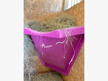 Load image into Gallery viewer, Pink Hay Feeder attached to wall inside stables. 
