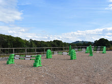 Load image into Gallery viewer, Eco Superior Set in arena. From left to right, 1 pair of MultiJumps, 1 pair of Hedgehogs, 1 pair of 8 Cups and 1 pair of Combi Blocks all in our Eco material. The set has 11 9 Band Practice or Pro Poles. 
