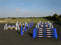 Photograph of the PolyJumps Advanced set in an arena. The set's contents are as follows: 1 set of Combi Blocks, 4 sets of Cross Wings and 3 sets of 8 Cups with 4 Bridge Fillers and 21 Poles. This set's colour scheme is primarily Blue.