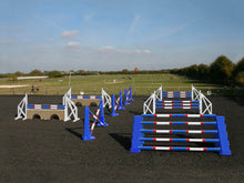 Load image into Gallery viewer, Photograph of the PolyJumps Advanced set in an arena. The set&#39;s contents are as follows: 1 set of Combi Blocks, 4 sets of Cross Wings and 3 sets of 8 Cups with 4 Bridge Fillers and 21 Poles. This set&#39;s colour scheme is primarily Blue.

