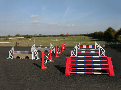 Photograph of the PolyJumps Advanced set in an arena. The set's contents are as follows: 1 set of Combi Blocks, 4 sets of Cross Wings and 3 sets of 8 Cups with 4 Bridge Fillers and 21 Poles. This set's colour scheme is primarily Red.