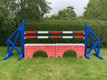 Load image into Gallery viewer, Photograph of a pair of Blue Cross Wings with 2 9 Band Practice Poles coloured: Red, Blue &amp; White. Underneath the poles sit 2 White Bridge Fillers with Red Brick Graphics on them. 
