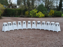 Load image into Gallery viewer, 12 Dressage Tower Markers sat on gravel. Black painted letters on all sides (A, B, C, E, F, H, K, M, R, S, P, V).
