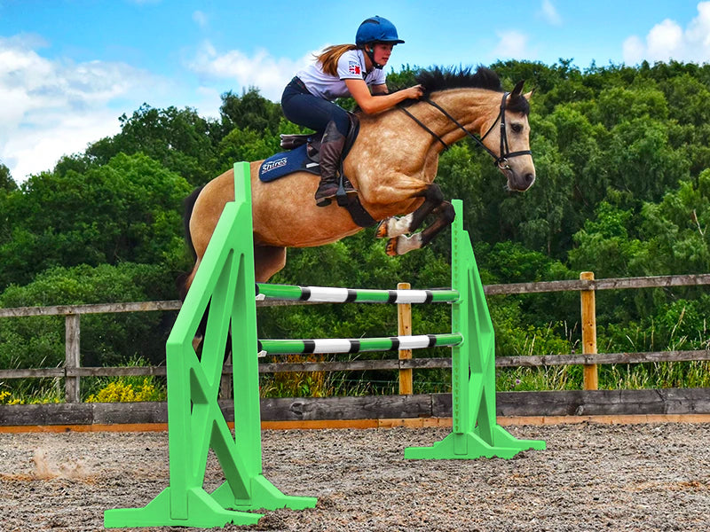 Horse and rider jumping over a pair of Eco Green Cross Wings with 2 9 Band Practice Poles. 