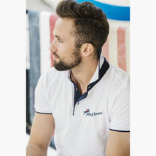 Load image into Gallery viewer, Model wearing White Poloshirt, raised collar revealing Navy Blue contrast fabric. PolyJumps Logo on wearer&#39;s left chest.
