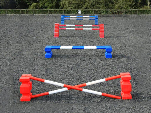 4 rows of jumps. From front to back is a red pair of PolyJump Blocks with 2 5 band red and white poles. Behind that fence is the same in blue. Then a pair of red MultiJumps with 2 red and white 5 band poles. Finally a pair of blue MultiJumps with blue and white poles.