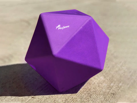 Purple Treat Ball on floor with white PolyJumps logo facing upward.