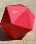 Red Treat Ball on floor with white PolyJumps logo facing upward.