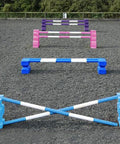 4 rows of jumps. From front to back is a baby blue pair of PolyJump Blocks with 2 5 band baby blue and white poles. Behind that fence is the same in blue. Then a pair of pink MultiJumps with 2 pink and white 5 band poles. Finally a pair of purple MultiJumps with purple and white poles.