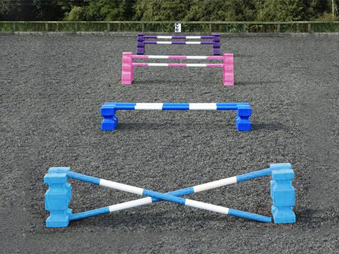 4 rows of jumps. From front to back is a baby blue pair of PolyJump Blocks with 2 5 band baby blue and white poles. Behind that fence is the same in blue. Then a pair of pink MultiJumps with 2 pink and white 5 band poles. Finally a pair of purple MultiJumps with purple and white poles.
